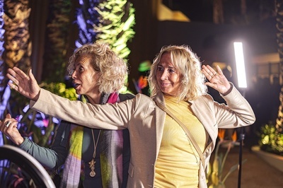 two women standing next to each other with their arms outstretched - 