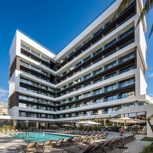un gran edificio con una piscina al frente