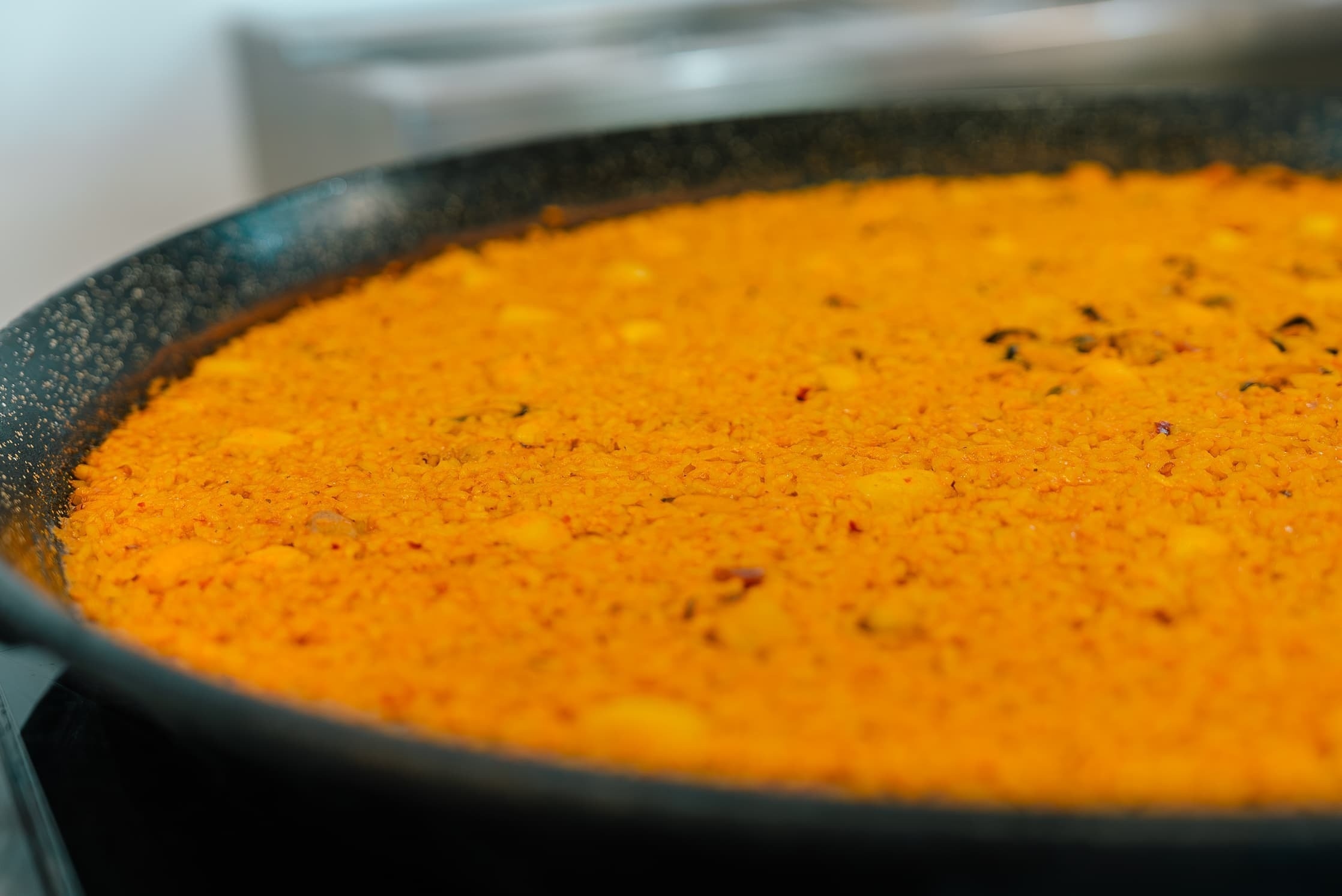 a pan filled with a thick orange colored rice