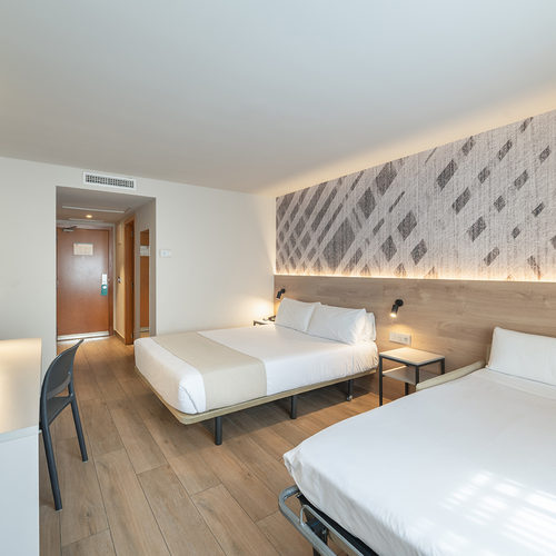 una habitación de hotel con dos camas y una televisión