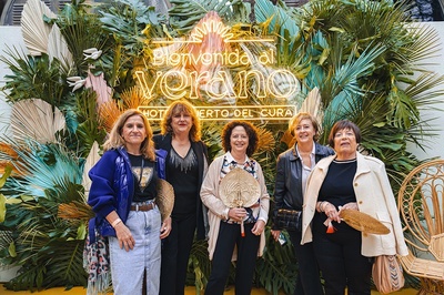 a group of women standing in front of a sign that says bienvenido al verano - 