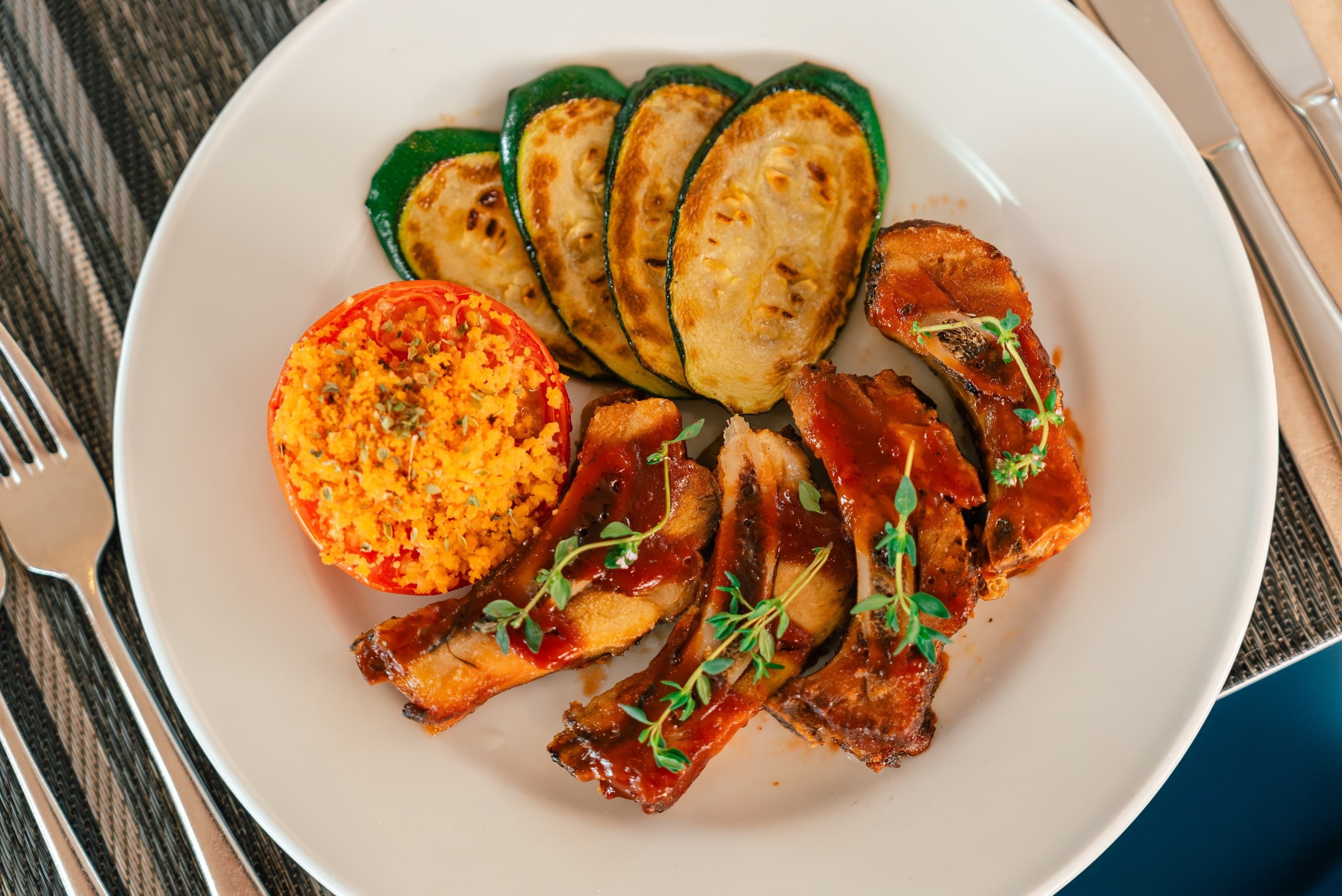 un plato blanco con costillas y verduras encima