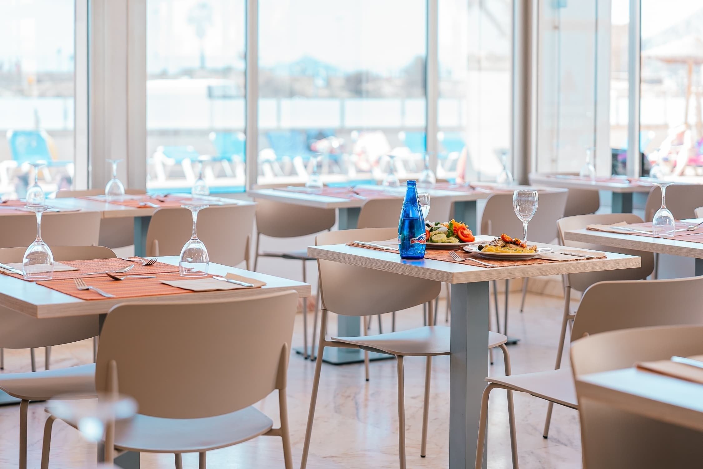 un restaurante con mesas y sillas y una botella de agua