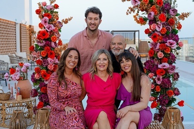 a group of people posing for a picture with flowers in the background - 