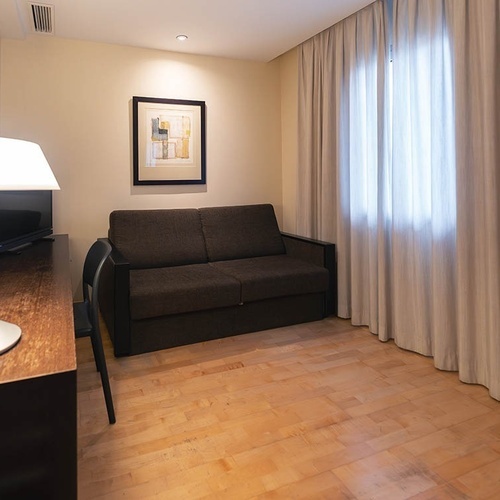 una habitación con un sofá y una lámpara y una pintura en la pared