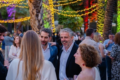 un grupo de personas están hablando en una fiesta al aire libre - 