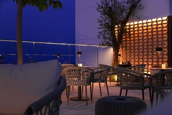 a group of people sitting at tables on a rooftop