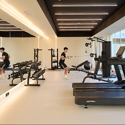 Gimnasio del hotel con equipo moderno, incluyendo cintas de correr y mancuernas. Perfecto para mantenerse en forma durante tu estancia. Port Hotels: Corporativa