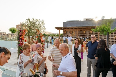 un grupo de personas de pie en una terraza con botellas de champán - 