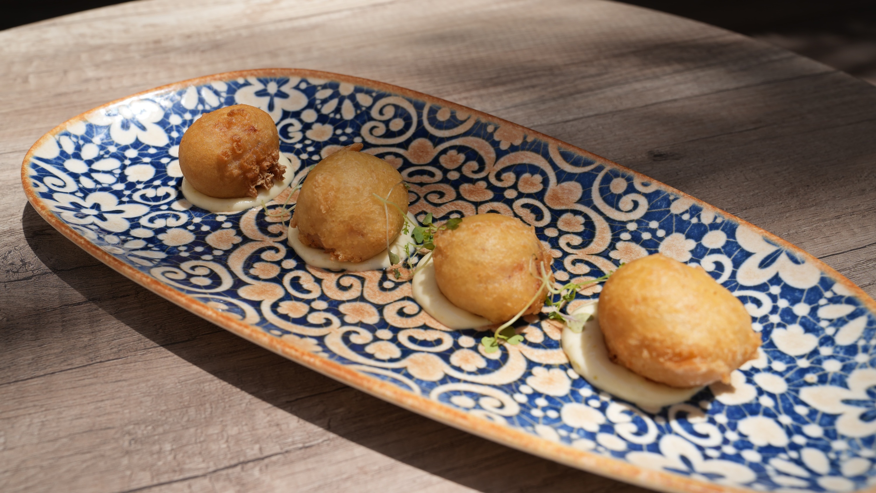 a blue and white plate with fried food on it