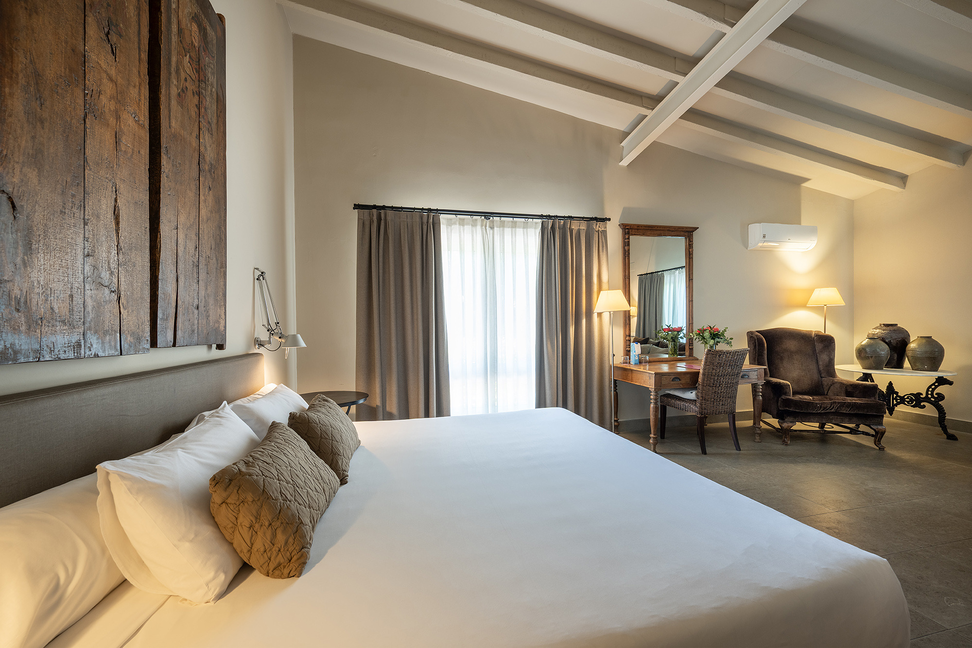 Habitación de hotel con cama, escritorio y sillón, decorada con Port Hotels: Huerto del Cura.