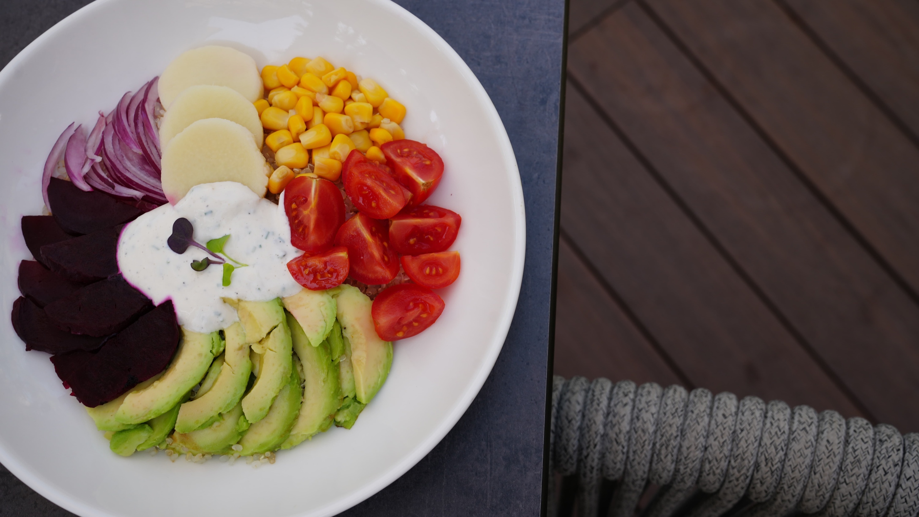 a white bowl filled with a variety of vegetables including avocado and tomatoes