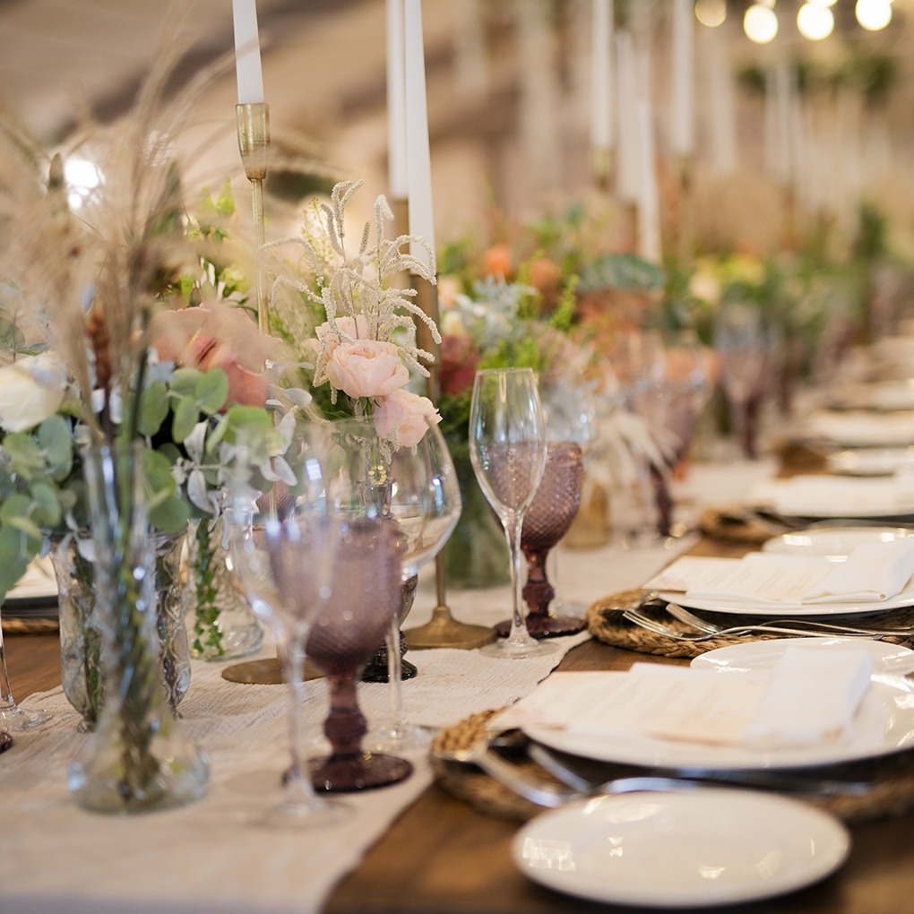una mesa con platos , copas , velas y flores