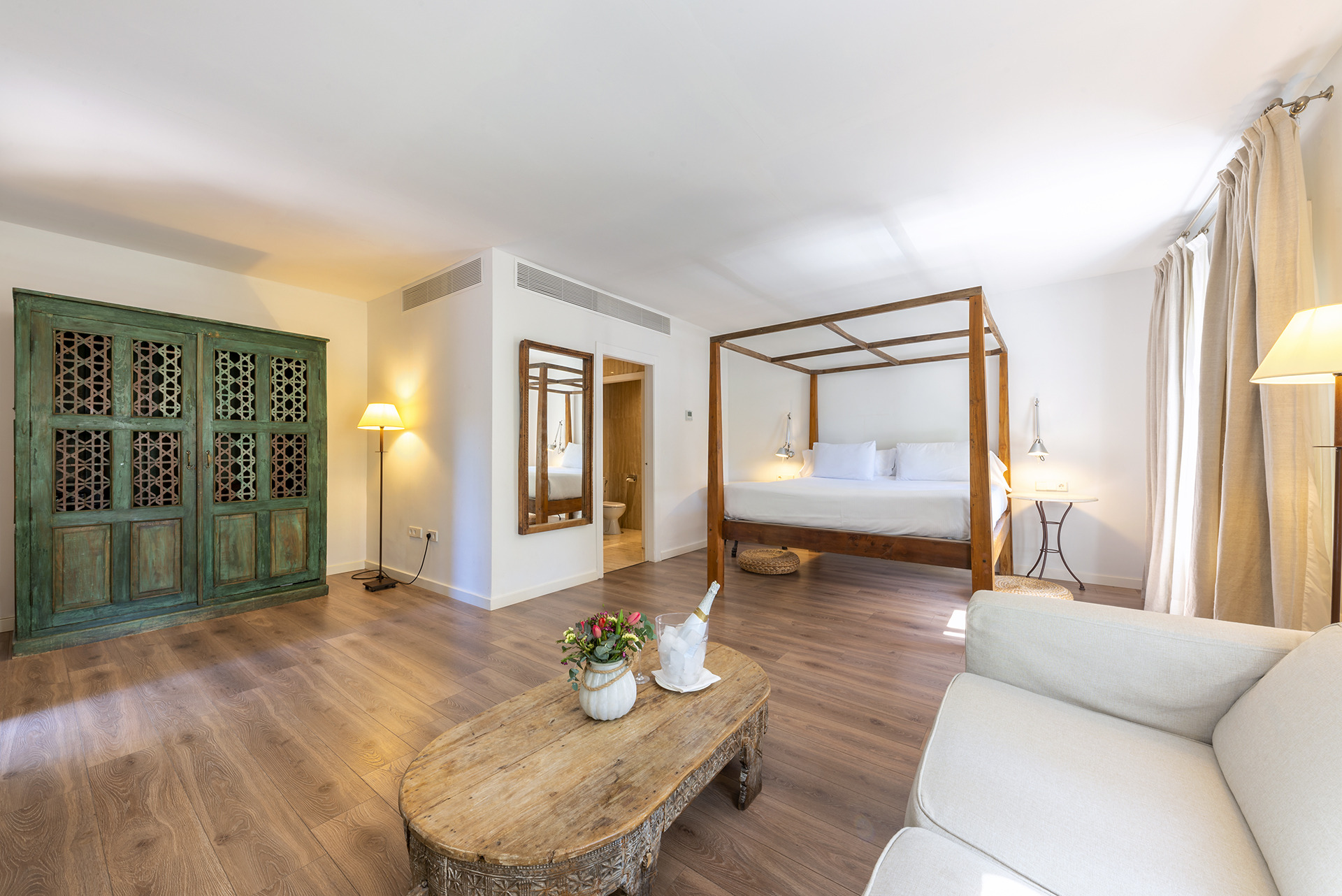 Suite de hotel de lujo con cama con dosel, Port Hotels: Huerto del Cura y elegante decoración.