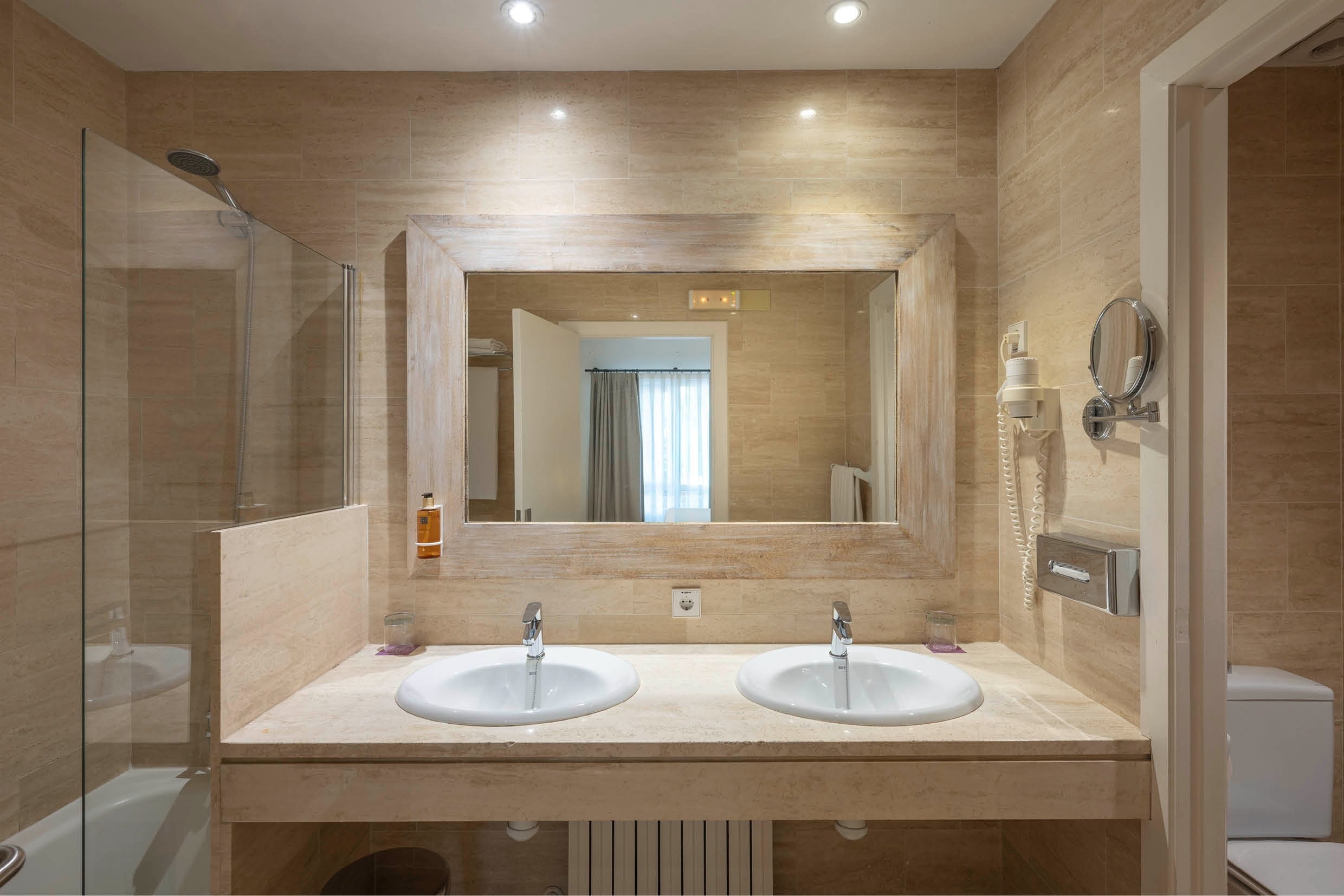 un baño con dos lavabos y un espejo grande