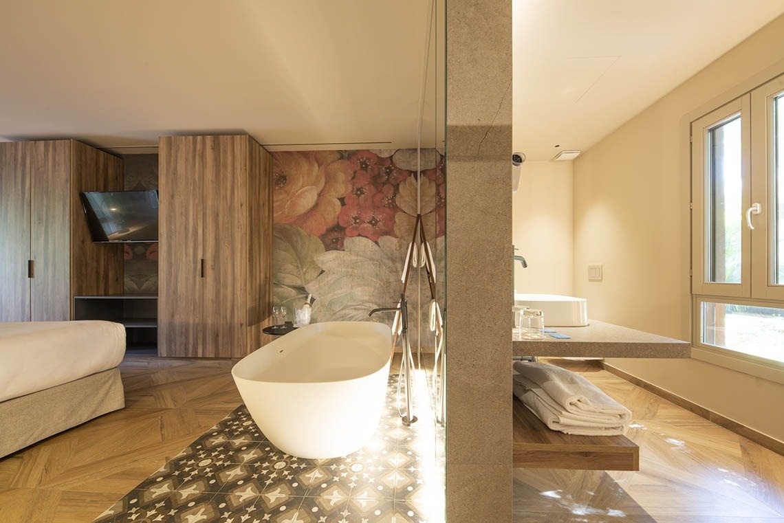 a bathroom with a bathtub and a floral wallpaper on the wall