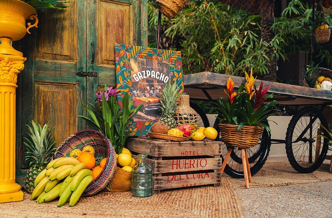 una caja de madera que dice huerto del cura está rodeada de frutas y flores