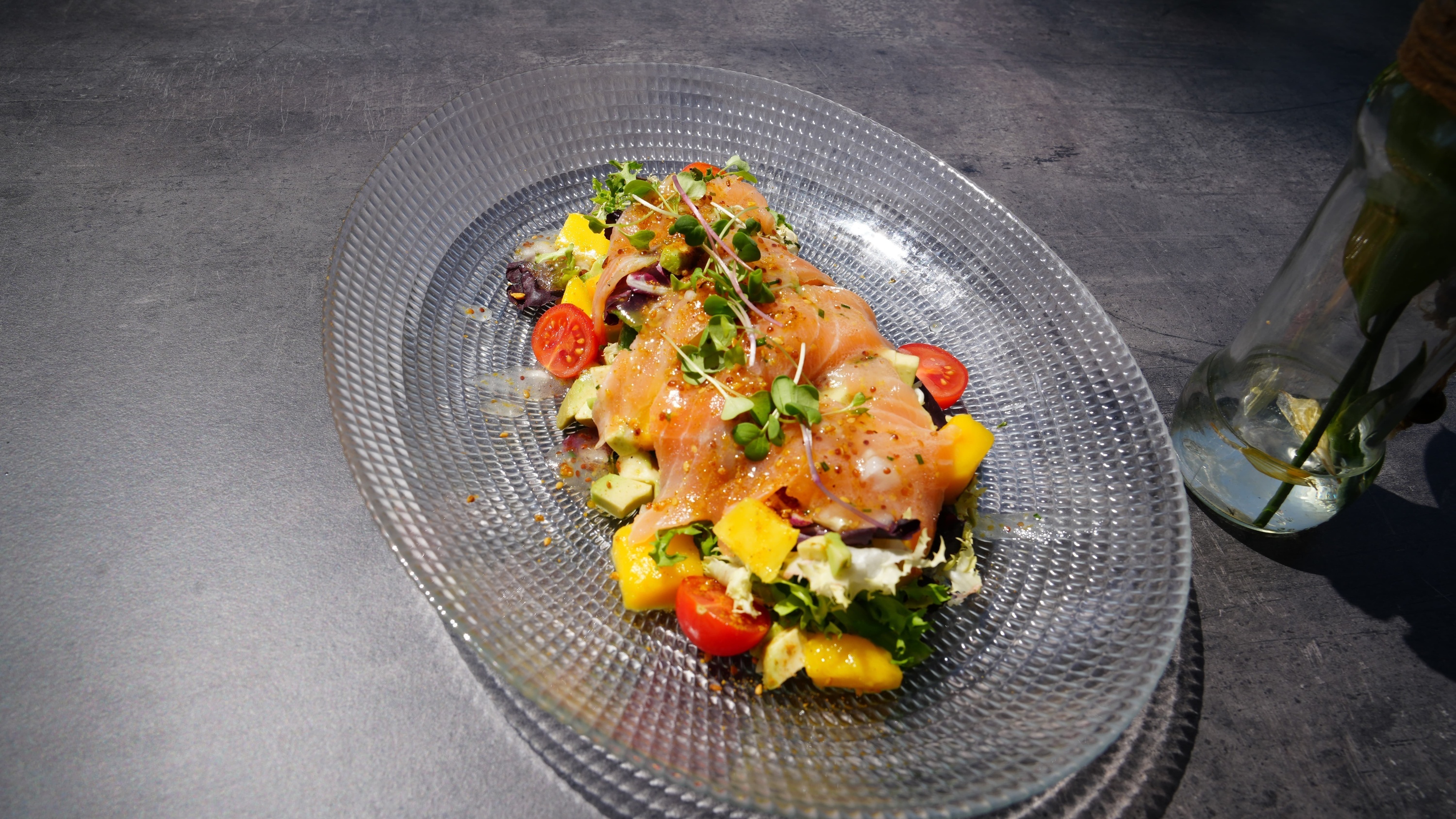 un plato de comida con salmón y verduras sobre una mesa