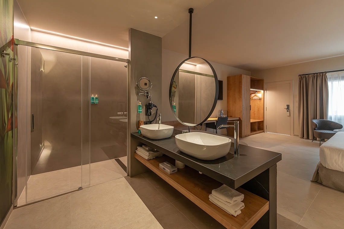 un baño de hotel con dos lavabos y un espejo