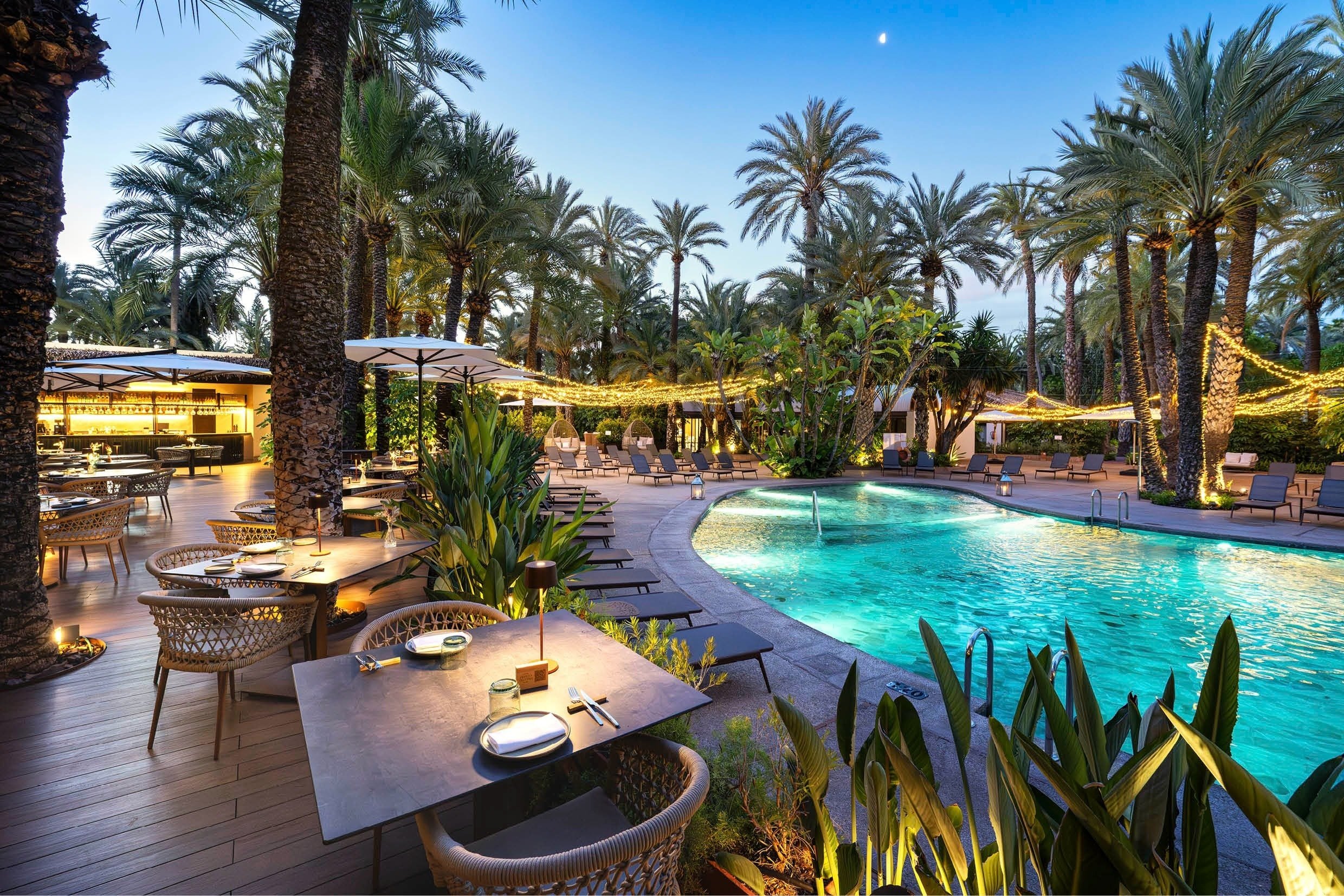 a woman sitting at a table with plates of food and a glass of wine
