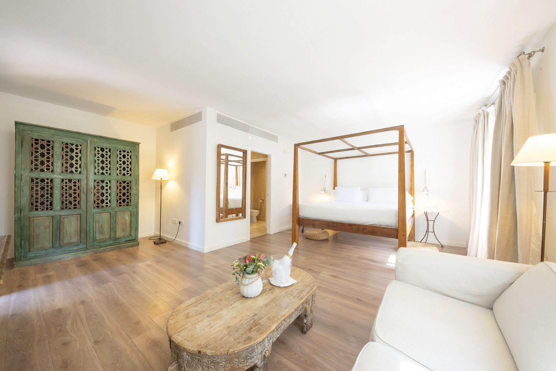 Suite de hotel con cama con dosel y sala de estar, ideal para Port Hotels: Huerto del Cura.