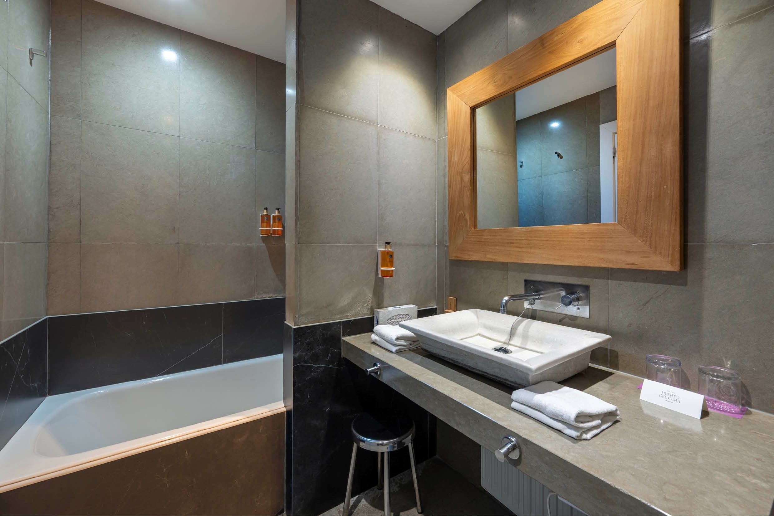 un baño con un lavabo y un espejo de madera