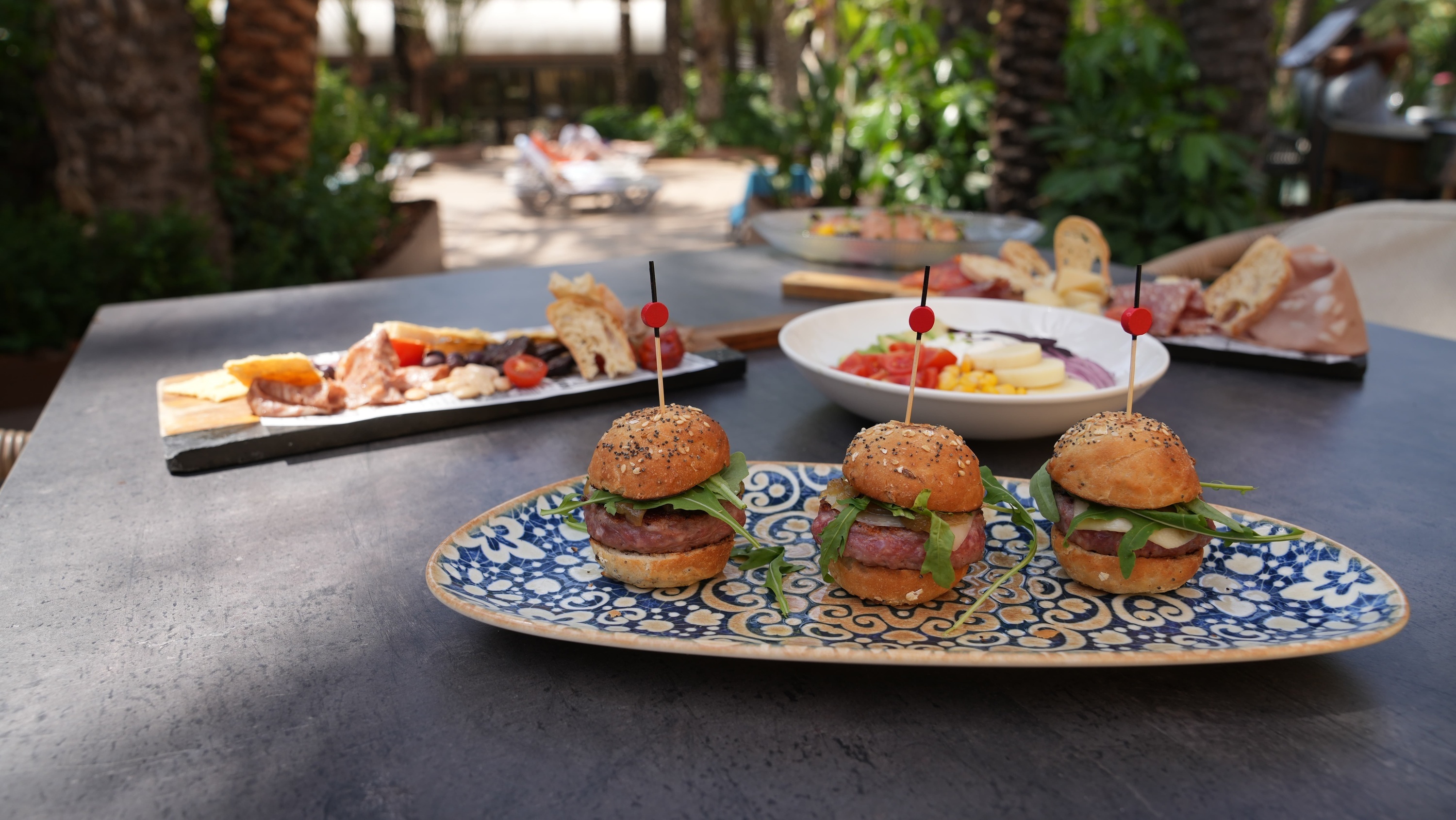 a blue and white plate with three hamburgers on it