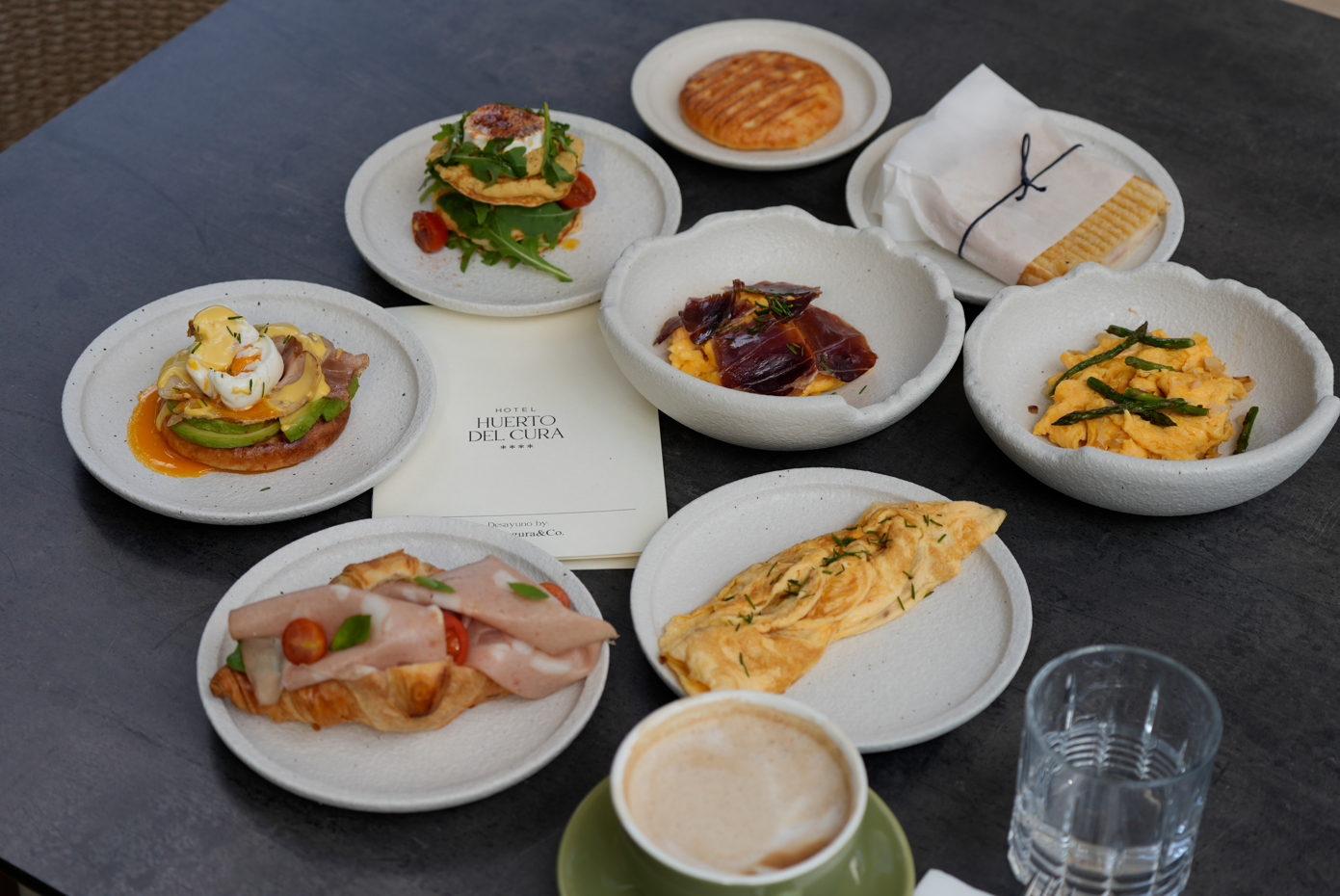 a table topped with a variety of food and a cup of coffee