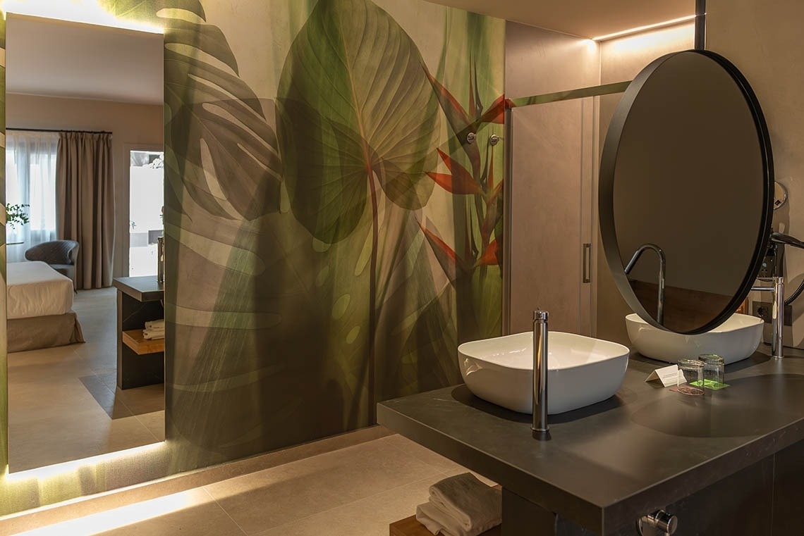 a bathroom with two sinks and a round mirror