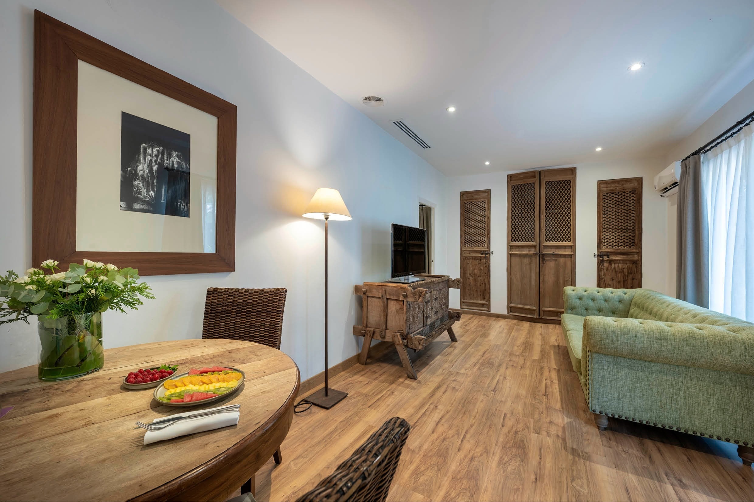 una sala de estar con un sofá verde y una mesa de madera