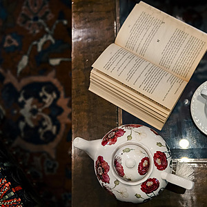 Taza de té y libro abierto en una mesa de hotel, ideal para @Porton de la Cabrera.