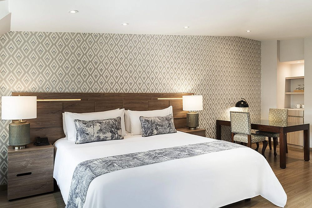 Porton de la Cabrera: cómoda cama king, detalles decorativos y área de trabajo en habitación de hotel de lujo