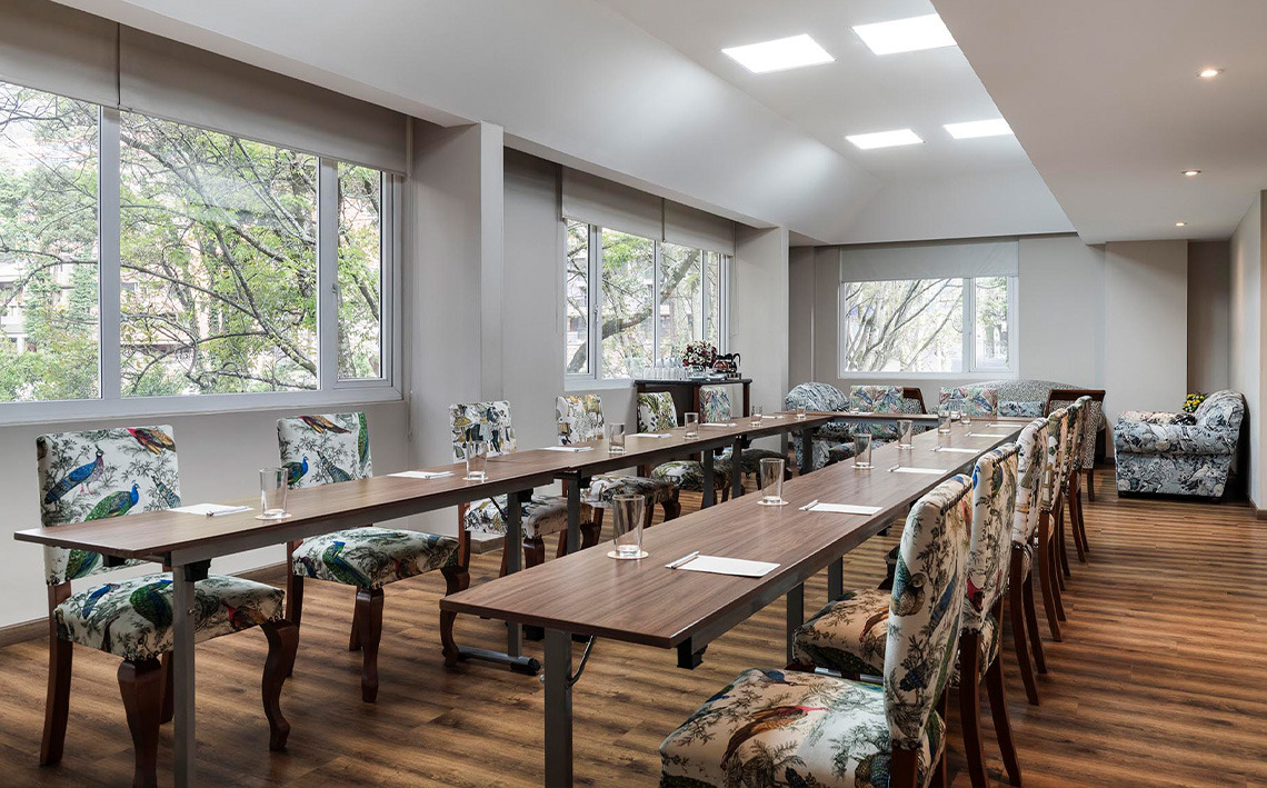 Sala de conferencias y reuniones con sillones estampados y vista a árboles. Ideal para tu Porton de la Cabrera.