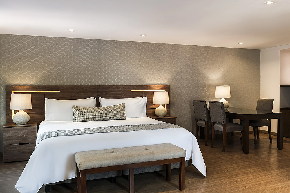 Suite de lujo con cama grande, mesa y sillas Porton de la Cabrera.