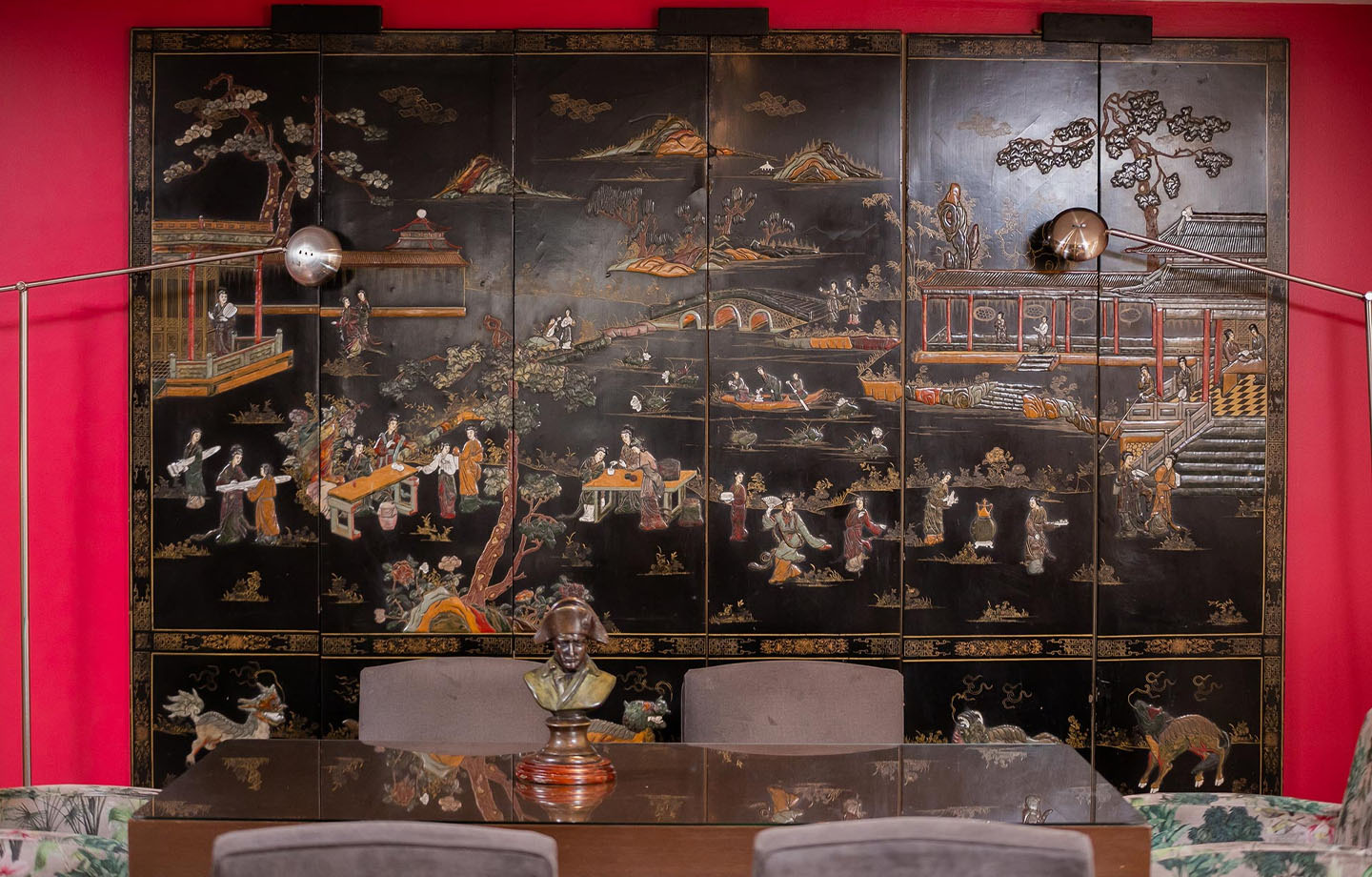 Exótico biombo «Portón de la Cabrera» con escena oriental y lámparas modernas.