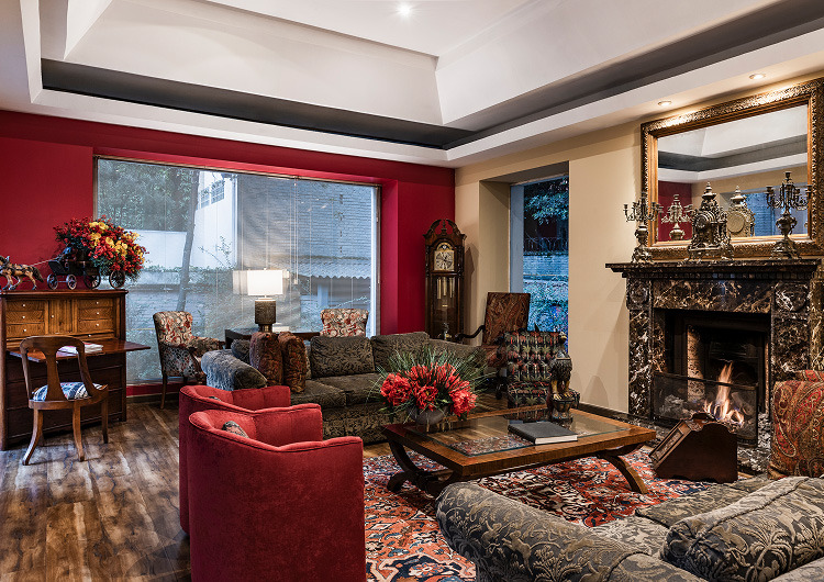 Elegante sala de estar de hotel con chimenea, Hotel cinco estrellas en Jerez | Casa Palacio María Luisa y muebles de lujo.
