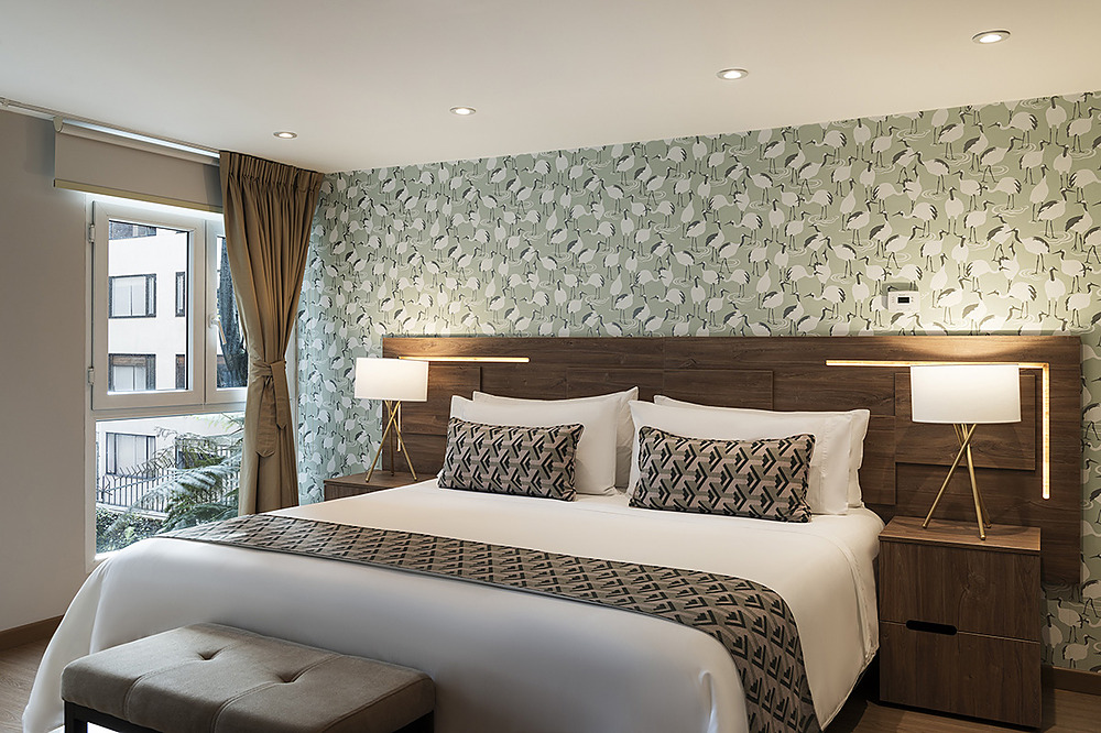 Dormitorio moderno con cama king, decoración de aves enPorton de la Cabrera, mesitas de noche y ventana.