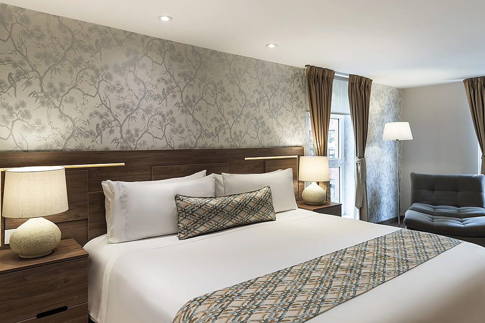 Amplia y acogedora habitación de hotel con cama grande, Porton de la Cabrera y decoración elegante.