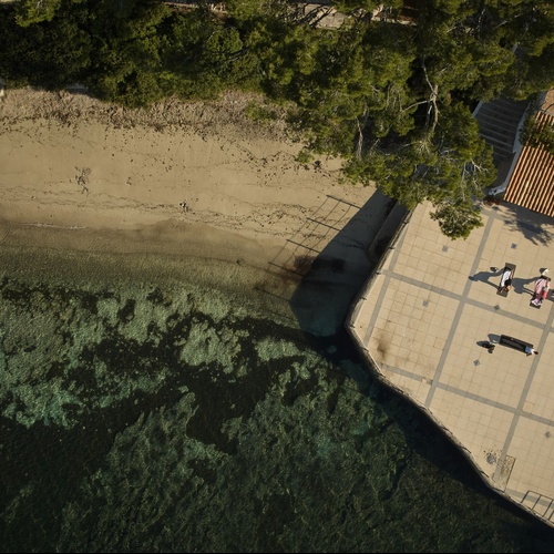 an aerial view of a beach with people laying on the sand