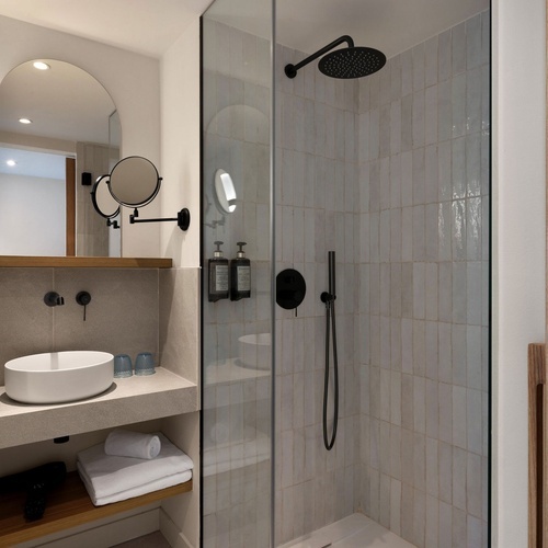 un baño con lavabo y ducha de vidrio