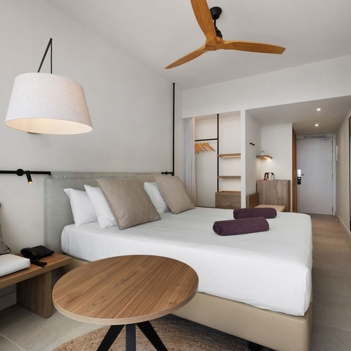 una habitación con una cama y un ventilador de techo