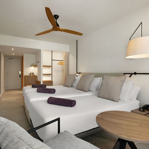 a hotel room with two beds and a ceiling fan