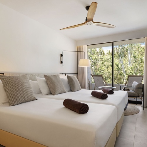 una habitación con dos camas y un ventilador de techo