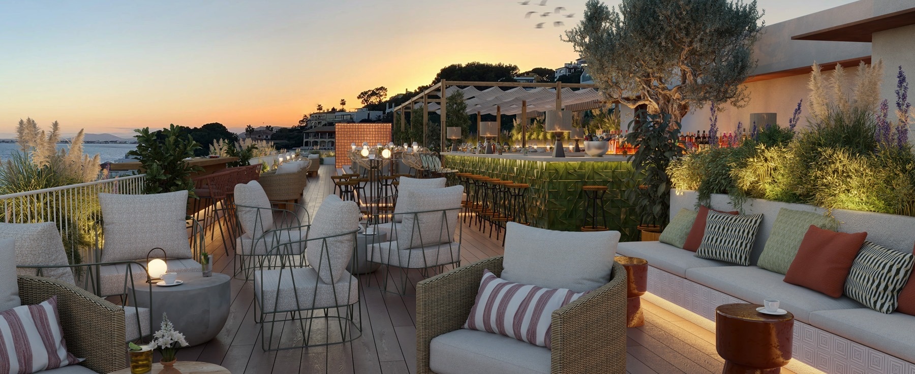 une terrasse avec des chaises et des canapés au coucher du soleil