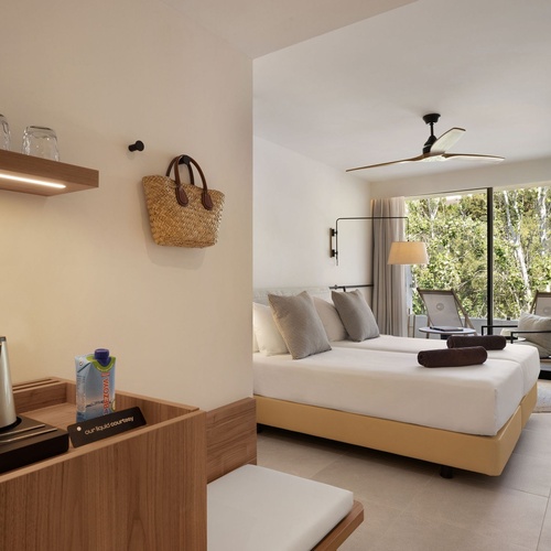 una habitación de hotel con dos camas y una mesa de madera