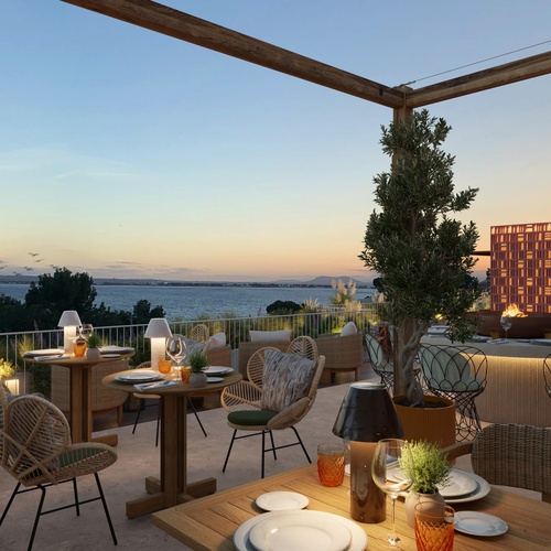 une terrasse avec des tables et des chaises au coucher du soleil