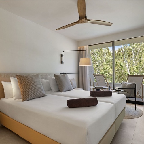 una habitación con dos camas y un ventilador de techo