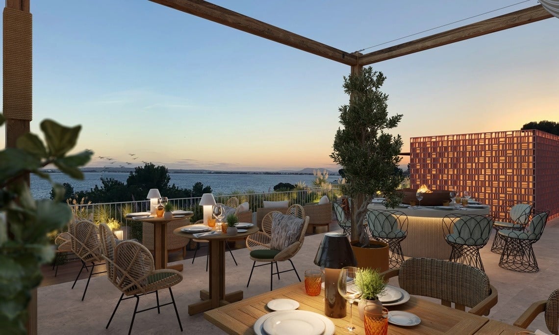 une terrasse avec des tables et des chaises au coucher du soleil