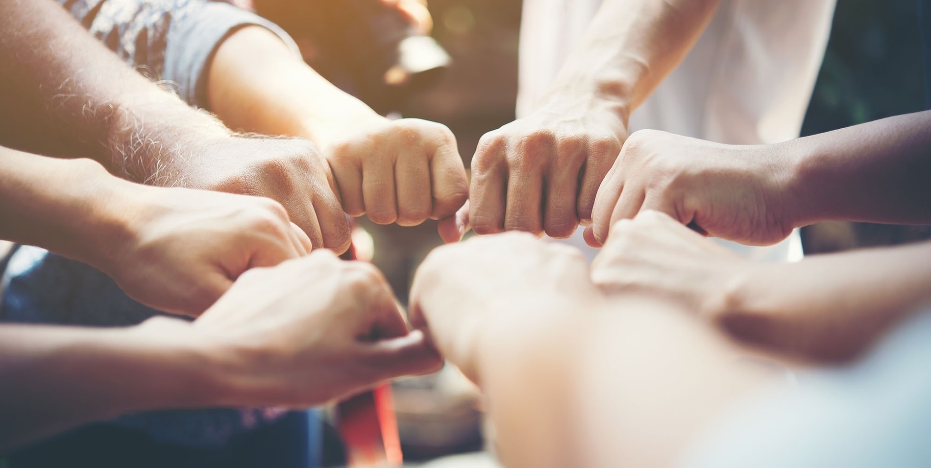a group of people putting their hands together in a circle