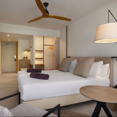 a hotel room with two beds and a ceiling fan